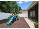 Backyard featuring a playset, white fence, and access to a screened lanai at 13310 Tiger Lilly Ln, Tampa, FL 33625