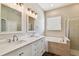 Elegant bathroom with double sinks, soaking tub, and a separate shower at 13310 Tiger Lilly Ln, Tampa, FL 33625