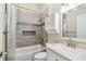 Well-maintained bathroom features a shower-tub combo with stylish tiling, vanity, and storage at 13310 Tiger Lilly Ln, Tampa, FL 33625