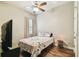Bedroom with ceiling fan, wood-look flooring, and flower patterned bedding at 13310 Tiger Lilly Ln, Tampa, FL 33625