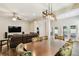 Open-concept dining area with wood floors and a modern light fixture next to a living area at 13310 Tiger Lilly Ln, Tampa, FL 33625