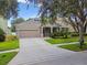 Charming single-Gathering home with a two-car garage, lush landscaping, and a well-maintained front lawn at 13310 Tiger Lilly Ln, Tampa, FL 33625