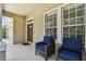 Inviting front porch features two comfortable chairs and a welcoming entryway, perfect for relaxing outdoors at 13310 Tiger Lilly Ln, Tampa, FL 33625