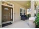 Inviting front porch with stylish seating, neutral wall color, and a view of the neighborhood at 13310 Tiger Lilly Ln, Tampa, FL 33625