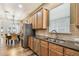 Kitchen area with stainless steel appliances, sink with window, wood cabinets, and granite countertops at 13310 Tiger Lilly Ln, Tampa, FL 33625