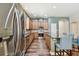 A spacious kitchen with stainless steel appliances, wood cabinets, and a breakfast bar with blue fabric chairs at 13310 Tiger Lilly Ln, Tampa, FL 33625