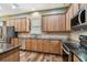 Kitchen featuring wood cabinets, stainless steel appliances, tile backsplash, and dark granite countertops at 13310 Tiger Lilly Ln, Tampa, FL 33625