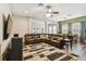 Spacious living room with large sectional sofa, decorative columns, and wood-look flooring at 13310 Tiger Lilly Ln, Tampa, FL 33625