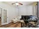 Bright home office featuring hardwood floors, a ceiling fan, and a comfortable sitting area with a workspace and large monitor at 13310 Tiger Lilly Ln, Tampa, FL 33625