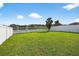 Spacious backyard featuring green grass, a lake view, and a white fence at 13324 Willow Bluestar Loop, Riverview, FL 33579