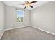 This is a bedroom with neutral carpeting and a view of a neighborhood at 13324 Willow Bluestar Loop, Riverview, FL 33579