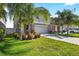 Charming two-story home with well-maintained landscaping, including palm trees and colorful flowers at 13324 Willow Bluestar Loop, Riverview, FL 33579
