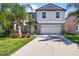 Charming two-story home with well-maintained landscaping, including palm trees and colorful flowers at 13324 Willow Bluestar Loop, Riverview, FL 33579