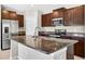 Kitchen island featuring granite countertops, a stainless steel refrigerator, and dark wood cabinets at 13324 Willow Bluestar Loop, Riverview, FL 33579