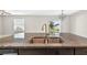 Close-up of kitchen island features granite countertops and a double sink with views of the back yard at 13324 Willow Bluestar Loop, Riverview, FL 33579