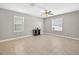 Bright living room with neutral walls, ceiling fan, tile floors, and lots of natural light from two windows at 13324 Willow Bluestar Loop, Riverview, FL 33579