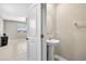 Stylish powder room featuring a pedestal sink and an oval mirror, connected to a larger space at 13324 Willow Bluestar Loop, Riverview, FL 33579