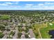 Overhead shot featuring a neighborhood of single-Gathering homes, mature trees and a winding pathway around a pond at 1617 Leland Dr, Sun City Center, FL 33573