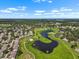 An aerial view captures homes nestled within a lush, green community, complete with a pond and golf course at 1617 Leland Dr, Sun City Center, FL 33573