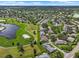 An aerial view of a residential community featuring well-maintained lawns, trees, and winding roads at 1617 Leland Dr, Sun City Center, FL 33573