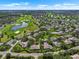 An aerial view showcasing homes nestled within a lush, green community, complete with a pond and golf course at 1617 Leland Dr, Sun City Center, FL 33573
