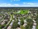 An aerial view captures a neighborhood with mature trees, ponds, and winding roads on a sunny day at 1617 Leland Dr, Sun City Center, FL 33573