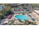Aerial view showcasing a large pool area with multiple umbrellas and lounge chairs, ideal for community relaxation at 1617 Leland Dr, Sun City Center, FL 33573