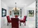 Dining room featuring bright light fixture, red chairs, and tile floors at 1617 Leland Dr, Sun City Center, FL 33573