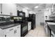 Galley style kitchen with white cabinets and black appliances at 1617 Leland Dr, Sun City Center, FL 33573