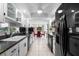 Galley kitchen with white cabinets and black appliances connects to the dining area at 1617 Leland Dr, Sun City Center, FL 33573