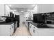 This kitchen includes white cabinets, black appliances, and tile floors at 1617 Leland Dr, Sun City Center, FL 33573
