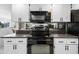 Kitchen features white cabinets, tile flooring, and black appliances at 1617 Leland Dr, Sun City Center, FL 33573