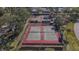 Aerial view of several fenced tennis courts, surrounded by trees and greenery, offering a private setting at 1617 Leland Dr, Sun City Center, FL 33573