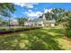Expansive backyard featuring a tennis court, manicured lawn, and stunning view of the beautiful home exterior at 1628 Long Bow Ln, Clearwater, FL 33764