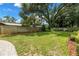 Spacious backyard featuring a well-manicured lawn, privacy fence and mature trees creating a serene outdoor space at 1628 Long Bow Ln, Clearwater, FL 33764