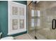 Modern bathroom with glass-enclosed shower, neutral tile, and a window with plantation shutters at 1628 Long Bow Ln, Clearwater, FL 33764