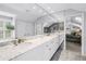 Bright bathroom featuring white marble floors and vanity, large mirrors, and walk-in closet at 1628 Long Bow Ln, Clearwater, FL 33764