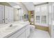 Bright bathroom featuring white cabinetry, white tiled floor, and plantation shutters at 1628 Long Bow Ln, Clearwater, FL 33764