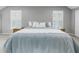 Spacious bedroom featuring light blue bedding, bedside tables and light-filtering shuttered windows at 1628 Long Bow Ln, Clearwater, FL 33764