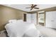 Cozy bedroom featuring white bedding, a ceiling fan, and a window with shutters at 1628 Long Bow Ln, Clearwater, FL 33764