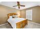 Cozy bedroom featuring a wooden bed frame, neutral walls, and a ceiling fan at 1628 Long Bow Ln, Clearwater, FL 33764