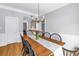Dining area with wood floors, chandelier, and view into kitchen with bar top at 1628 Long Bow Ln, Clearwater, FL 33764