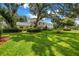 Beautiful home with manicured lawn and lush landscaping, shaded by mature trees at 1628 Long Bow Ln, Clearwater, FL 33764