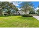 Beautifully landscaped front yard of an elegant home showcasing curb appeal and mature trees at 1628 Long Bow Ln, Clearwater, FL 33764