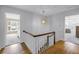 Bright upstairs hallway with hardwood floors, showcasing access to bedrooms and a charming pendant light at 1628 Long Bow Ln, Clearwater, FL 33764