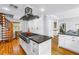 Spacious kitchen features an island cooktop, stainless hood, and adjacent dining area at 1628 Long Bow Ln, Clearwater, FL 33764