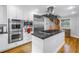 Gourmet kitchen features stainless appliances, island with cooktop, and spiral staircase at 1628 Long Bow Ln, Clearwater, FL 33764