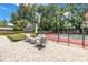 Charming patio area featuring comfortable seating and lush landscaping near a tennis court at 1628 Long Bow Ln, Clearwater, FL 33764
