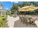 Landscaped patio featuring a dining area, tennis court, and lounge space for outdoor enjoyment at 1628 Long Bow Ln, Clearwater, FL 33764
