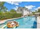 Backyard pool with a view of the home, pool-side seating, and lush green hedges at 1628 Long Bow Ln, Clearwater, FL 33764